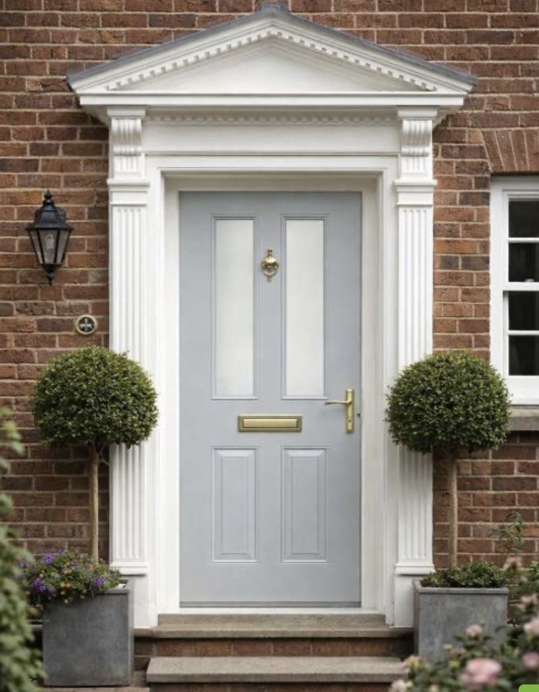Traditional grey painted entrance door with a decorative surround