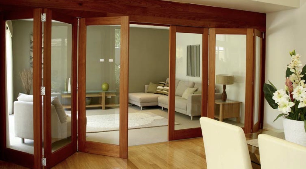 Wide glazed hardwood room divider with folding doors